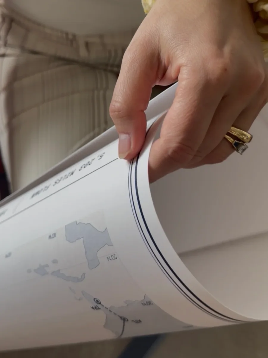 The thick matte paper print, gently curled in hand